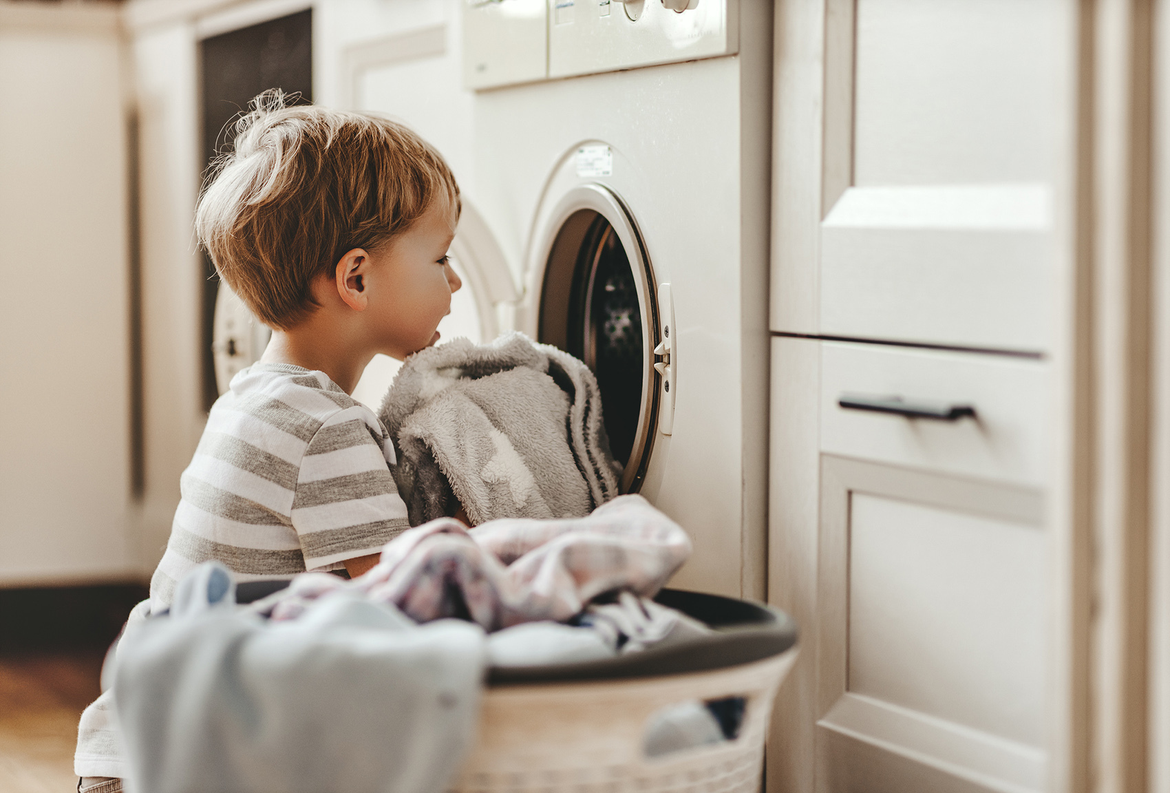 Dziecko wkłada pranie do pralki