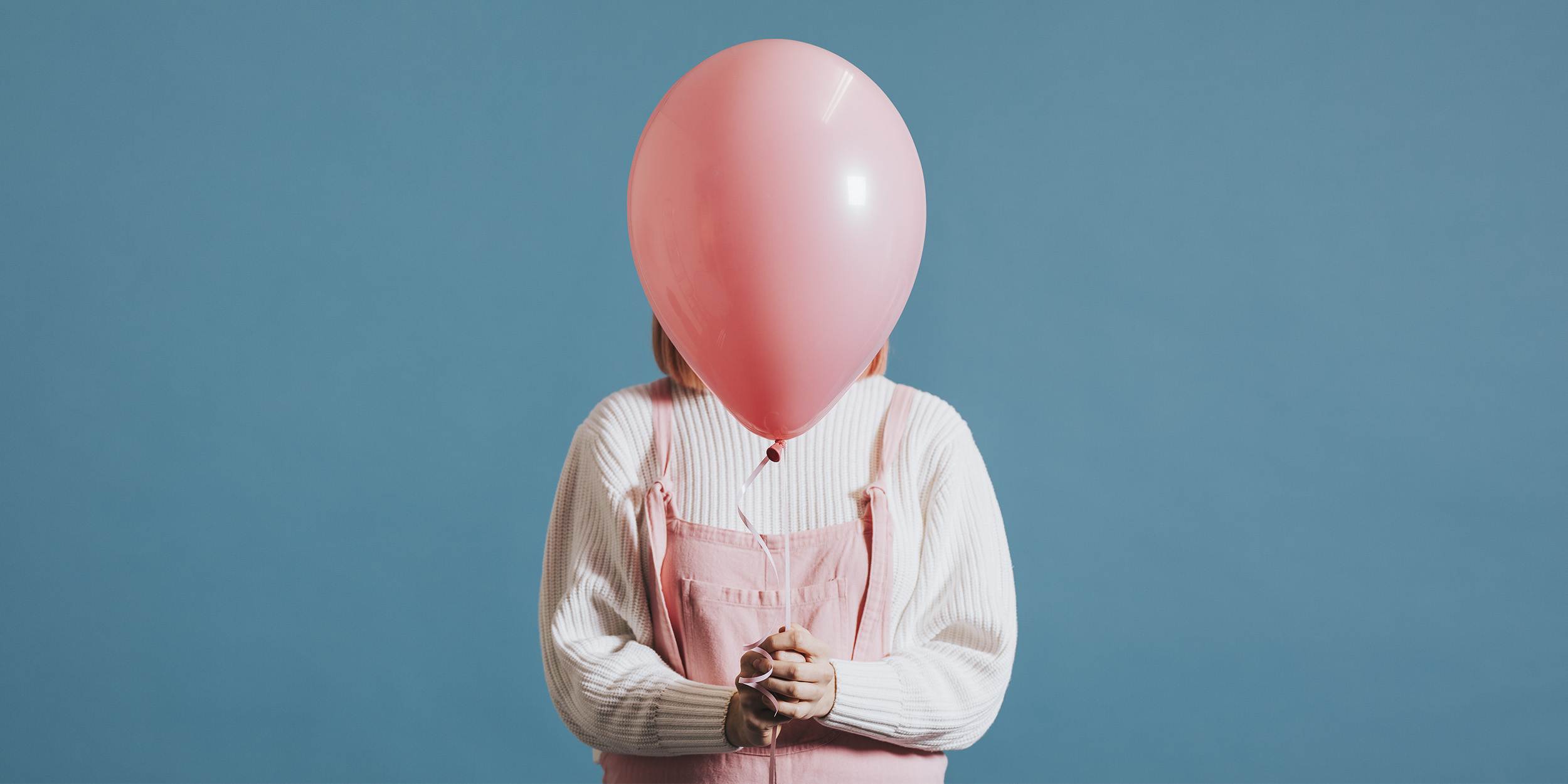 nastolatka ukryta za różowym balonem