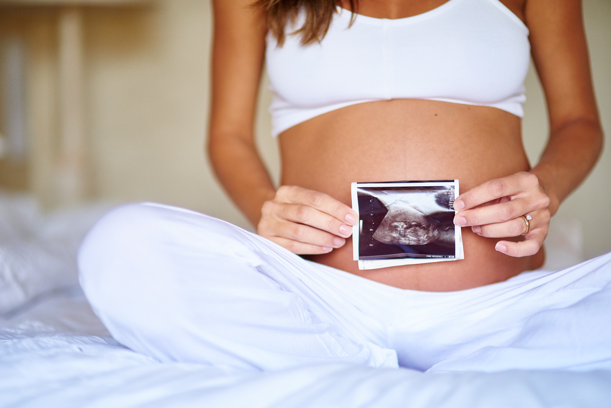 kobieta w ciąży ze zdjęciem USG dziecka