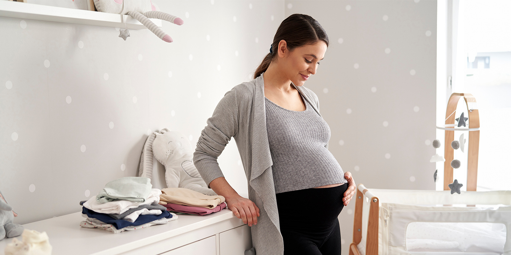 Kobieta w ciąży w dziecięcym pokoiku /fot. Adobe Stock